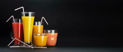 Assortment of citrus cocktails on black background with copy space photo