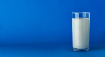 Glass of milk isolated on blue background with copy space photo