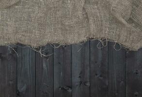 Burlap or sack on dark wooden background photo