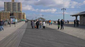 nuevo York ciudad, Estados Unidos - noviembre 22, 2018 Brighton playa terraplén y personas cerca mar. riegelmann paseo marítimo video