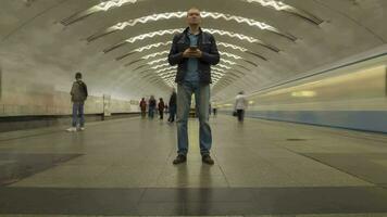 Time Lapse of Man Standing Still in Underground Metro Station and Using Mobile Phone. Crowd of People and Passing Trains video