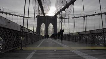 NEW YORK CITY, USA - NOVEMBER 25, 2018 Brooklyn Bridge, Joggers and Tourists. Steadicam Shot, Moving Sideways. Slow Motion video