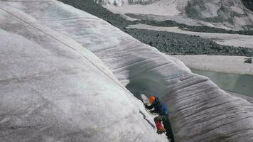 alpinista homem dentro grampos é usando ascender em fixo corda em íngreme declive dentro montanhas. lento movimento video