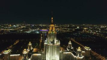 Moscú, 2018 - Moscú estado Universidad principal instalaciones y iluminado Moscú horizonte a claro invierno noche. Rusia. aéreo vista. zumbido es orbital alrededor. estableciendo Disparo video
