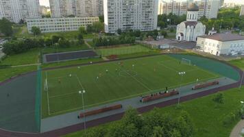 Moskva, 2017 - flygande över grön fotboll fält. fotboll match i stad parkera. kamera luta ner. antenn se. video