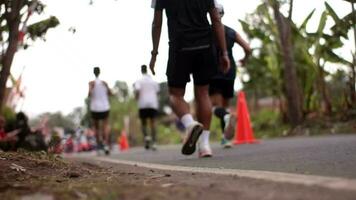 2023 Marathon- Läufer sind Vorbeigehen durch ein Dorf Straße. video