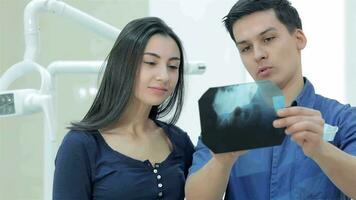 dentista muestra un paciente rayos X de el dientes video