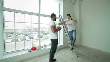 Two workers break and snack after make repairs in a new apartment video