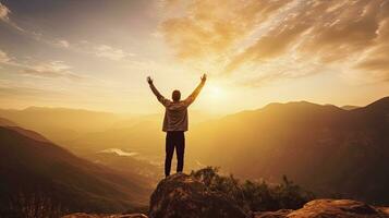 Positive man celebrating with arms raised up at Mountain landscape at sunset, Generative AI photo