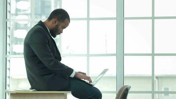 African businessman sitting and works on laptop video