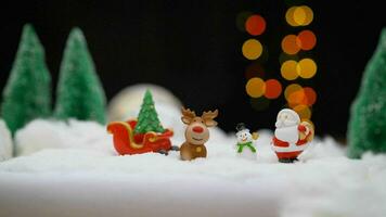 Santa Claus with a deer and a snowman on the background of light bulbs. Santa Claus, snowman, deer. photo