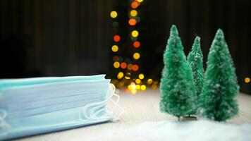 Christmas New Year background with branches of a Christmas tree and a medical mask. Horizontal orientation, selective focus. Christmas medical background. Christmas background and medical masks. photo