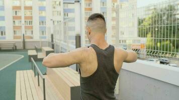 Bodybuilder doing exercises in the open air. Man is exercising at open air gym. photo