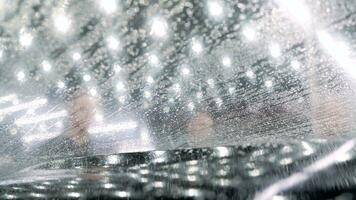 The protective film is glued on the soot of the car. The protective film is glued to the soot of the car. Protective film for the car. Worker hands installs car paint protection film. photo