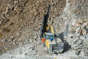 Drilling machine in open cast mining quarry photo