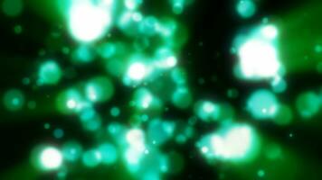 Abstract green blurred holiday background with magical bokeh of glowing bright light energy small particles of flying dots on a black background video