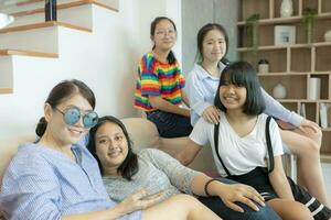 asian woman and teenager smiling with happiness in home living room photo