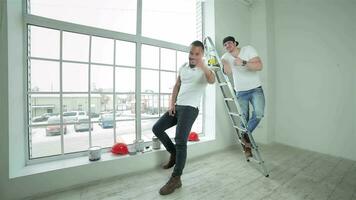 dois jovem construtores em pé às a escada video