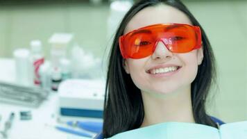 Girl sitting in the dental chair in red protective glasses video