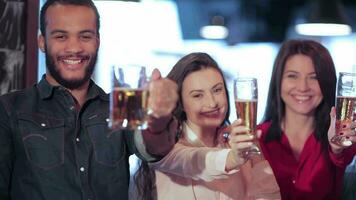 Young company lifts up a glass of beer video