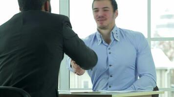 View of a handshake while two successful businessman video