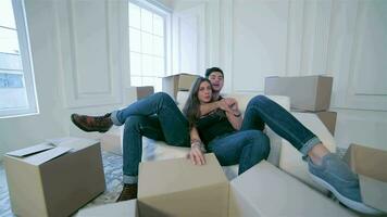 Couple in love hugging lying down among the boxes video