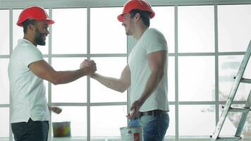 Two workers are shaking hands after a successful job video