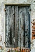 antiguo de madera ventana con de madera persianas en un ladrillo pared foto