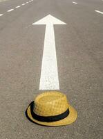 a hat sits on the road with an arrow pointing to it photo