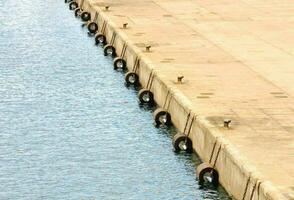 a row of tires on the side of a dock photo