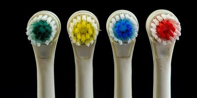 four toothbrushes with different colored bristles photo