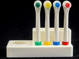 four toothbrushes with different colored bristles photo