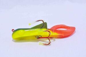 a yellow and red plastic lure on a white surface photo