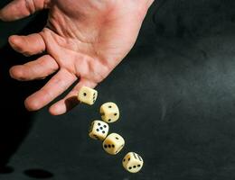 a hand holding a set of dice on a black background photo