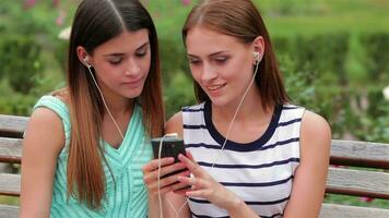 dois atraente meninas ouvindo para música video