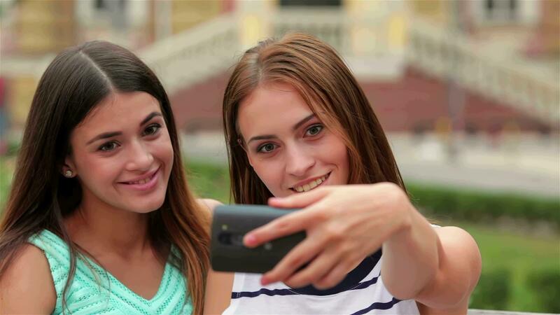 Smiling girls taking selfie with smartphone camera 34634264 Stock Video at Vecteezy
