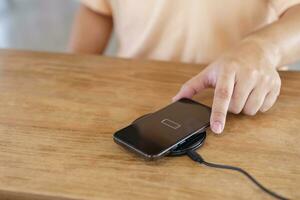 Charging mobile phone battery with wireless charging device in t photo