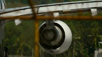 Close up of an airplane jet engine. Footage of an airplane taking off, haze on the airfield. View through the fence video