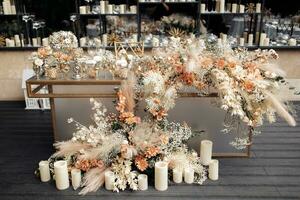 Front view of glamour table against mirrored wall with floating candles. Modern luxury wedding decor in expensive tones. photo