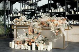 Side view glamour table against mirrored wall with floating candles in vases. Luxury event decor in expensive tones. photo