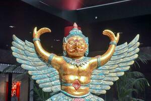 a statue of a golden winged man with his arms outstretched photo
