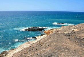 the ocean and cliffs are seen from a rocky cliff photo