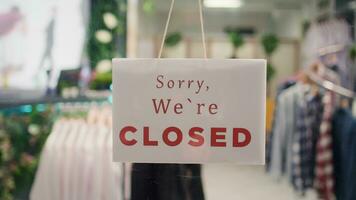 Trendy clothing store being closed at night after finished working hours. Extreme close up shot on sorry we are closed message sign on fashion boutique door in mall at shift end video