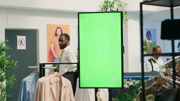 grön skärm kiosk i lyx Kläder affär reklam ny samling av elegant formell klädsel kläder. krom nyckel attrapp digital visa i mode boutique Begagnade till främja Lagra plagg video