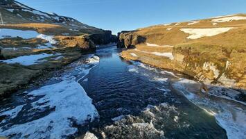 espectacular islandés natural Valle con grande rocoso colinas y crestas, fjadrargljufur río cañón en Islandia, rocas y laderas cubierto en nieve. ártico paisaje desierto paisaje en norte. foto