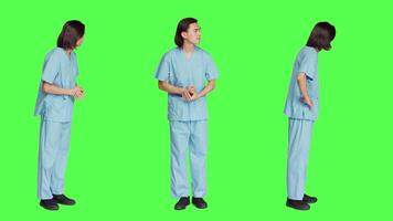 Over greenscreen wall, healthcare worker awaits for event, dressed in hospital protective outfit and being anxious. Man with medical expertise and natural abilities stands in studio. video