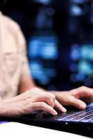 Close up shot of serviceman dealing with data center system failures, using laptop to order servers with high availability features to minimize downtime and prevent crashes photo