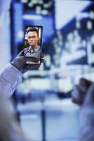 Woman in videocall with husband while walking around city streets at night, close up. Citizen using smartphone to show spouse surroundings in dimly illuminated urban center in blurry background photo