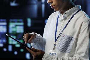 Meticulous programmer between server units providing processing resources for companies worldwide. Seasoned developer fixes high tech workplace supercomputers used for storing large databases photo