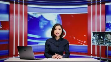 Asian presenter hosting news segment on live program, addressing all headlines in newsroom. Woman media journalist presenting breaking news and global events, television content newscast. photo